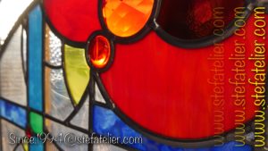 gros plan vitrail moderne verres à reliefs et cabochons rouges