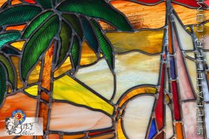 détail du vitrail traditionnel au plomb bateau et palmier au couché de soleil